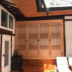un armadio in legno in una camera con pavimenti in legno. di Eoulim House a Andong