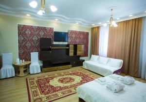 uma sala de estar com duas camas e um sofá em Hotel Alash em Astana