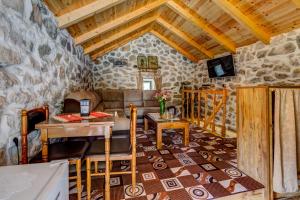sala de estar con pared de piedra en Ethno House Kosic, en Herceg-Novi