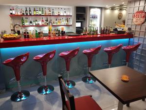 a bar with red chairs and a table in a restaurant at Amazones Villas Apartments in Stalís