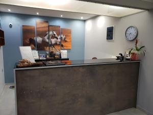 a reception counter with a clock on a wall at Amazones Villas Apartments in Stalís