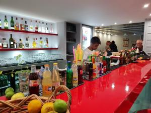 a bar with a red counter with bottles of drinks at Amazones Villas Apartments in Stalís
