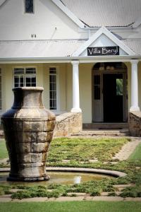 um grande vaso de pedra em frente a um edifício em Villa Beryl Guesthouse em Vryheid