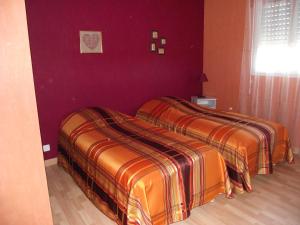 two beds in a bedroom with purple walls at Acaba d'Entrar in Le Caylar