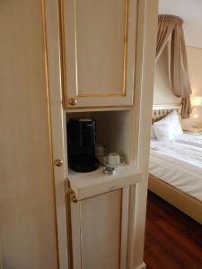 a cupboard with a coffee maker on a table next to a bed at Hotel Burg Staufenberg in Staufenberg