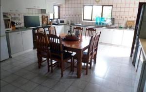 uma cozinha com uma mesa de madeira e cadeiras em Isigidi Beach House em Port Shepstone