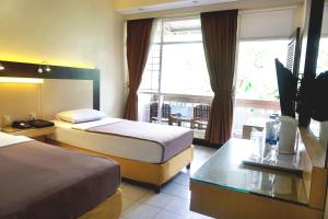 Ένα ή περισσότερα κρεβάτια σε δωμάτιο στο Hotel Puriwisata