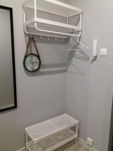 a white closet with a clock on a wall at Business Apartments 1 in Bydgoszcz