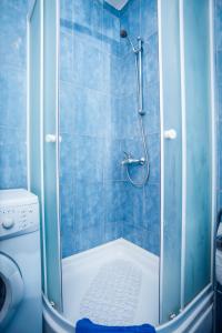 a blue tiled bathroom with a shower and a toilet at Margareta's Apartment in Kaštela +13 photos