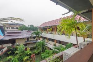 - une vue depuis le balcon d'un immeuble avec des palmiers dans l'établissement RedDoorz at Jalan Babepalar Rike Manado, à Manado