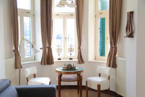 - un salon avec une table et 2 fenêtres dans l'établissement Hotel Vila Katrca, à Ljubljana