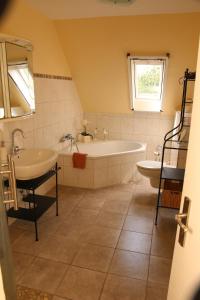 a bathroom with a tub and a sink at Ferienapartment Alpakas am Schloss in Hamminkeln +7 photos