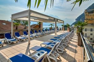 uma fila de espreguiçadeiras num pátio em Hotel Europa - Skypool & Panorama em Riva del Garda