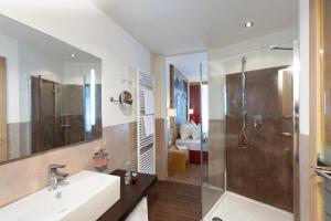 a bathroom with a sink and a shower at Hotel Amaten in Brunico