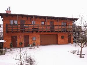 a large red brick building with a balcony at Pokoje U Anny i Łukasza in Swornegacie 