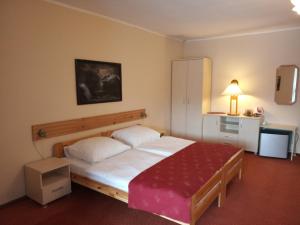 1 dormitorio con 1 cama grande con manta roja en Pensjonat Willa Edyta, en Mrągowo