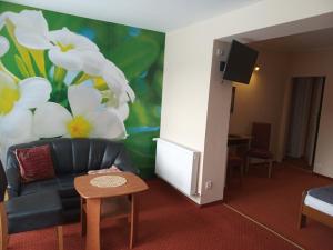 a living room with a couch and a flower mural at Pensjonat Willa Edyta in Mrągowo