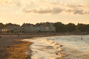 a beach with a group of people in the water at Ferienwohnung Sonnendeck Moba-Travel in Priwall