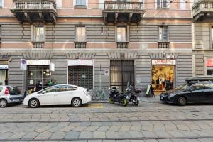 une voiture blanche garée devant un bâtiment dans l'établissement Buenos Aires & Lima Cosy Flat, à Milan