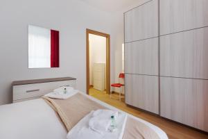 - une chambre avec un grand lit blanc et une grande armoire dans l'établissement Buenos Aires & Lima Cosy Flat, à Milan