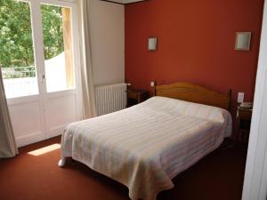 um pequeno quarto com uma cama e uma janela em Hôtel Le Castelet em Ax-les-Thermes