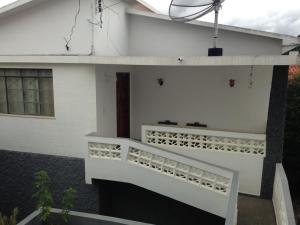 una casa blanca con una escalera blanca delante de ella en casa com piscina no centro da cidade, en São Lourenço