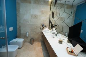 a bathroom with a sink and a toilet and a mirror at Valentino Rooms in Focşani +27 photos