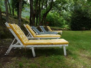 une rangée de chaises longues assises dans l'herbe dans l'établissement Hôtel Le Castelet, à Ax-les-Thermes