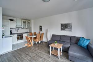 a living room with a couch and a table and a kitchen at Ferienwohnung Bootsteg Moba-Travel in Priwall