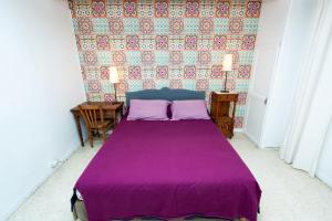 a bedroom with a purple bed with two pillows at Montpellier Boutonnet avec jardin in Montpellier