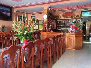 a restaurant with a bar with wooden chairs and a counter at Lotus Hotel in Sa Pa