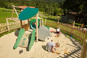 a man and a child playing in the sand in a playground at Strublhof in Rettenberg