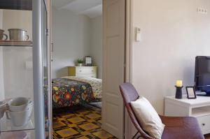 een kamer met een slaapkamer met een bed en een stoel bij Apartament en Plaça Nova , Palafrugell in Palafrugell