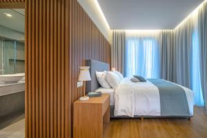 a bedroom with a bed and a bathroom with a tub at Glyfada Riviera Hotel in Athens