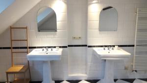 a bathroom with two sinks and two mirrors at CEP MAISONNETTE in Brussels