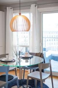 une salle à manger avec une table et des chaises en verre dans l'établissement BJØRVIKA APARTMENTS, Solsiden Area, Trondheim city center, à Trondheim