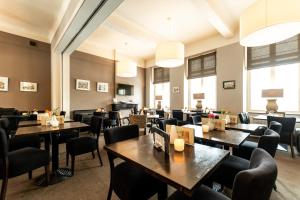 a restaurant with tables and chairs and windows at De Pastorie Bed & Breakfast in Roermond