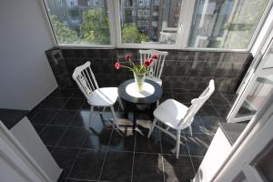 a balcony with a table and chairs and a vase of flowers at Selection Rooms in Belgrade