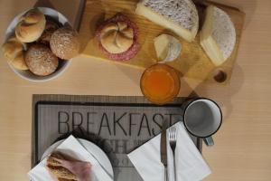 a table with a cutting board with breads and a plate of food at Hotel Europa Varese in Varese