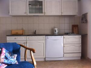 a kitchen with white cabinets and a white dishwasher at Apartment Stinica 31b in Jablanac