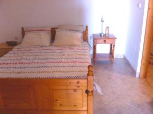 1 dormitorio con cama de madera y mesita de noche en Apartment Stinica 31b en Jablanac
