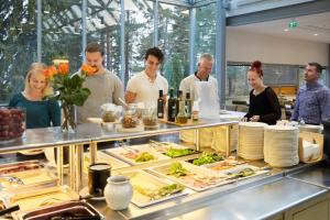 a group of people standing around a buffet with food at Kokoushotelli Murikanranta in Terälahti