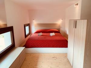 a bedroom with a red bed with two towels on it at Luxar room in Assemini