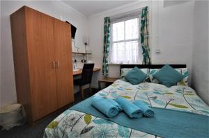 a bedroom with a bed with blue pillows on it at The Waterfront in Greenock