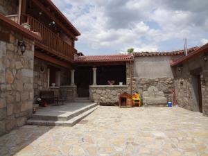 a patio of a house with a couch and a chair at casa rural La Gabina in Muñogalindo