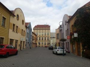 a street with cars parked on a cobblestone street at Apartmán Holandská 120 Beroun in Beroun