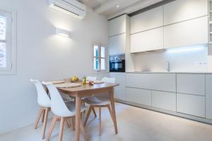a kitchen with a wooden table and white cabinets at Sa caseta Farinera in Sóller