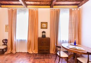 a dining room with a table and two windows at Castello di San Fabiano in Monteroni dʼArbia