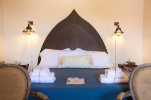 een slaapkamer met een bed met handdoeken erop bij Musciara Siracusa Resort in Siracusa