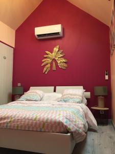 ein Schlafzimmer mit einer roten Wand und einem Bett in der Unterkunft Le Rouge & Blanc in Mormont